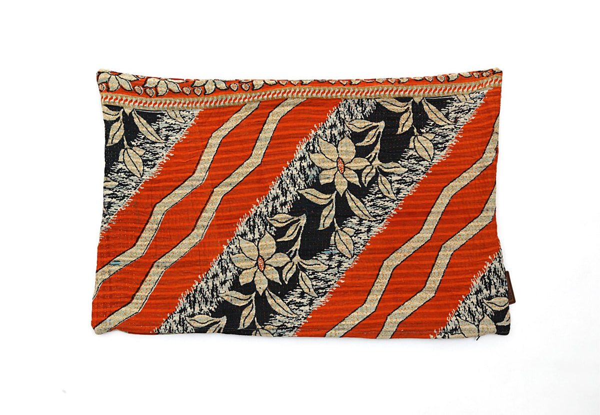 Pudebetrækket har et dynamisk mønster med orange og sorte striber samt blomstermotiver. Vælg denne pude for et unikt og kunstnerisk touch til dit rum. Størrelse: 60 x 40 cm.